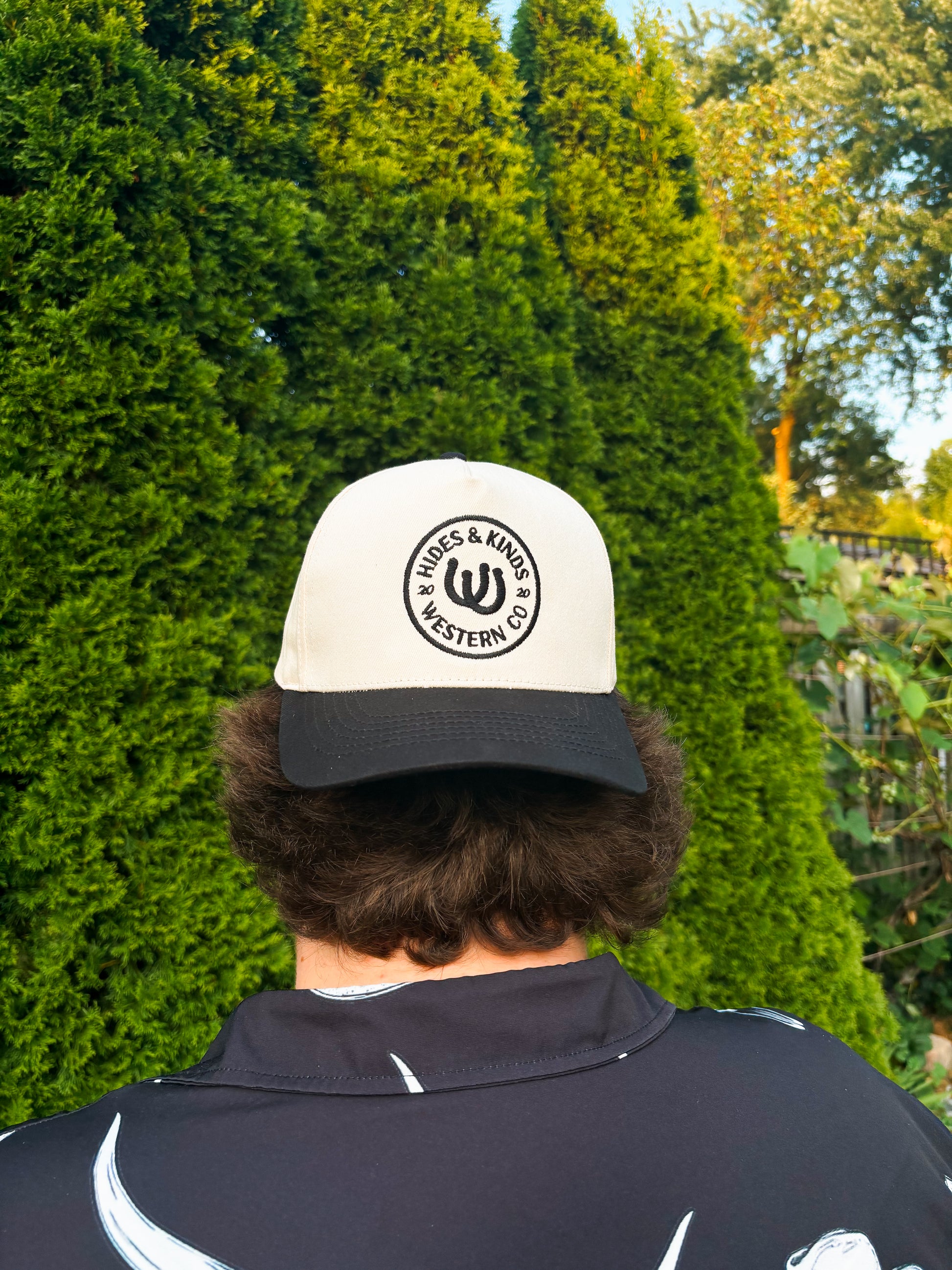 Back view of The Outrider Hat by Hides & Kinds, showing embroidered circular HK logo.