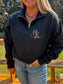 Close-up of the tooled turquoise logo embroidery on black quarter zip – textured western branding from Hides and Kinds.