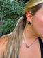 Close-up of Triple Stone Stud earrings in black onyx on model