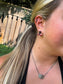 Close up of H&K Triple Stone Stud Earrings in Dahlia Rose pink stone worn with a black tank