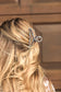 Close-up of turquoise and pearl western claw clip with silver frame outdoors