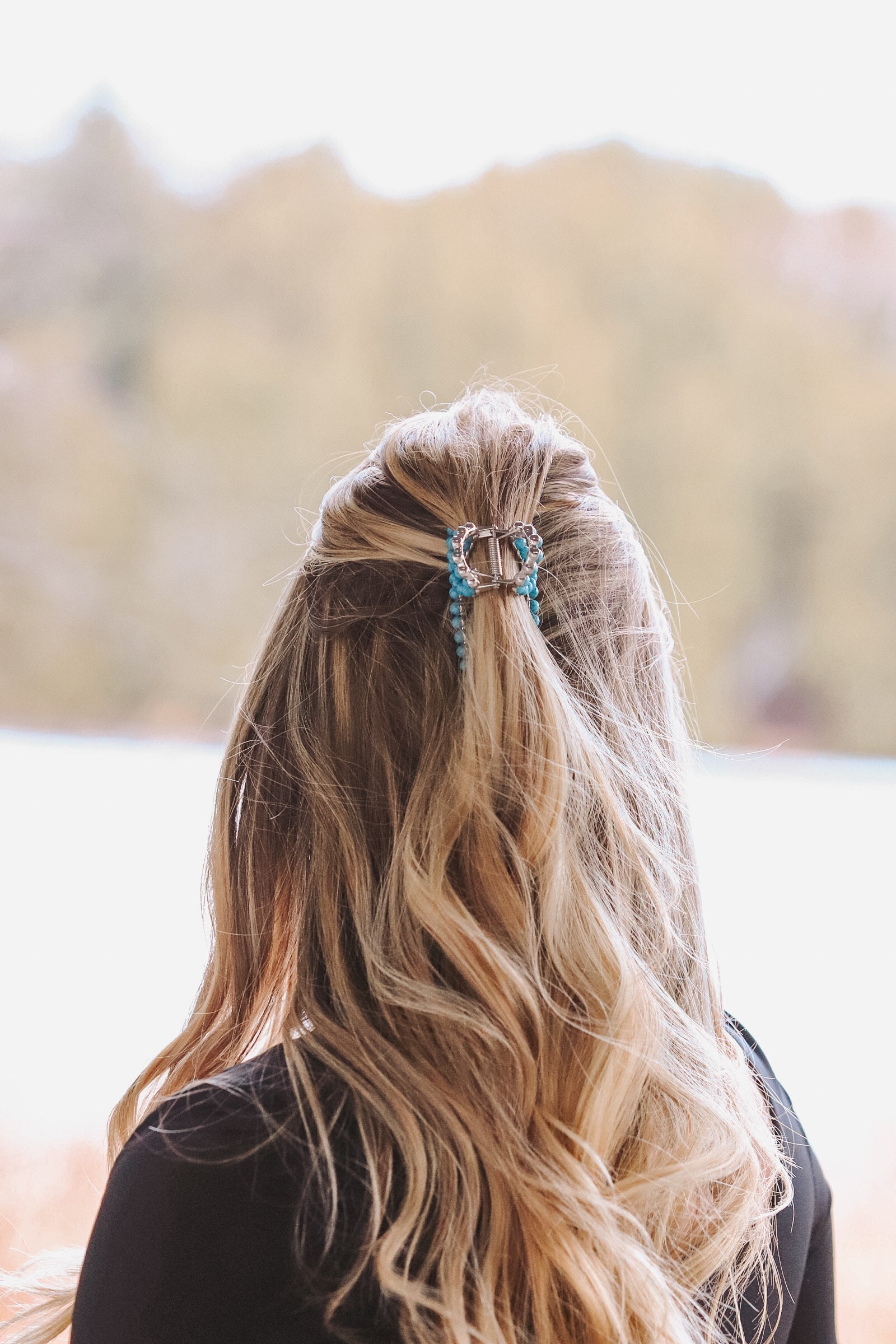 Close-up of turquoise claw clip with western-inspired beaded design
