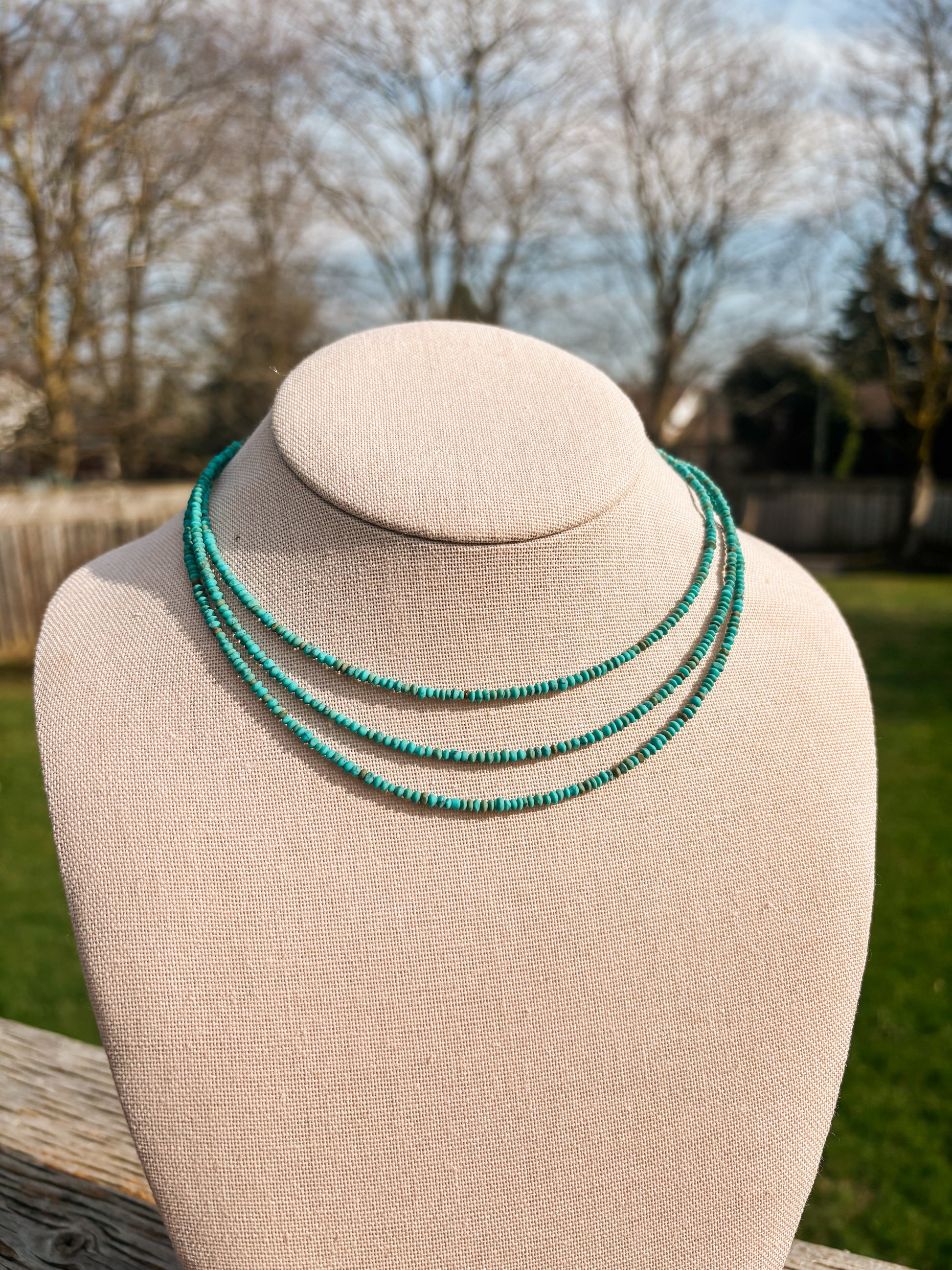 Full view of Turquoise Sierra Necklace with three beaded layers on jewelry bust stand.