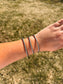 Western style twisted rope cuff bracelet stacked on wrist outdoors