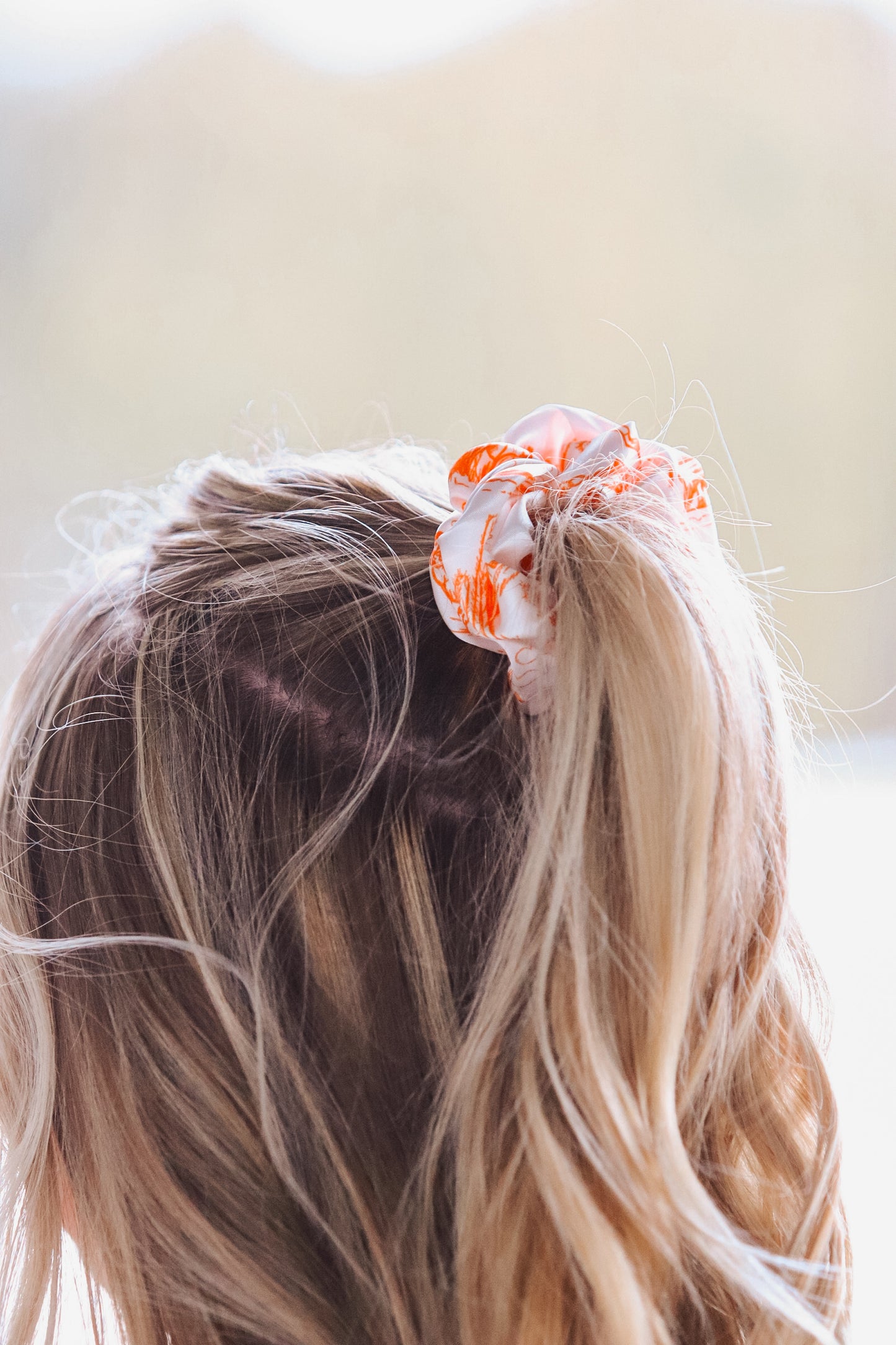 Western inspired orange and white cowboy scene scrunchie in blonde hair