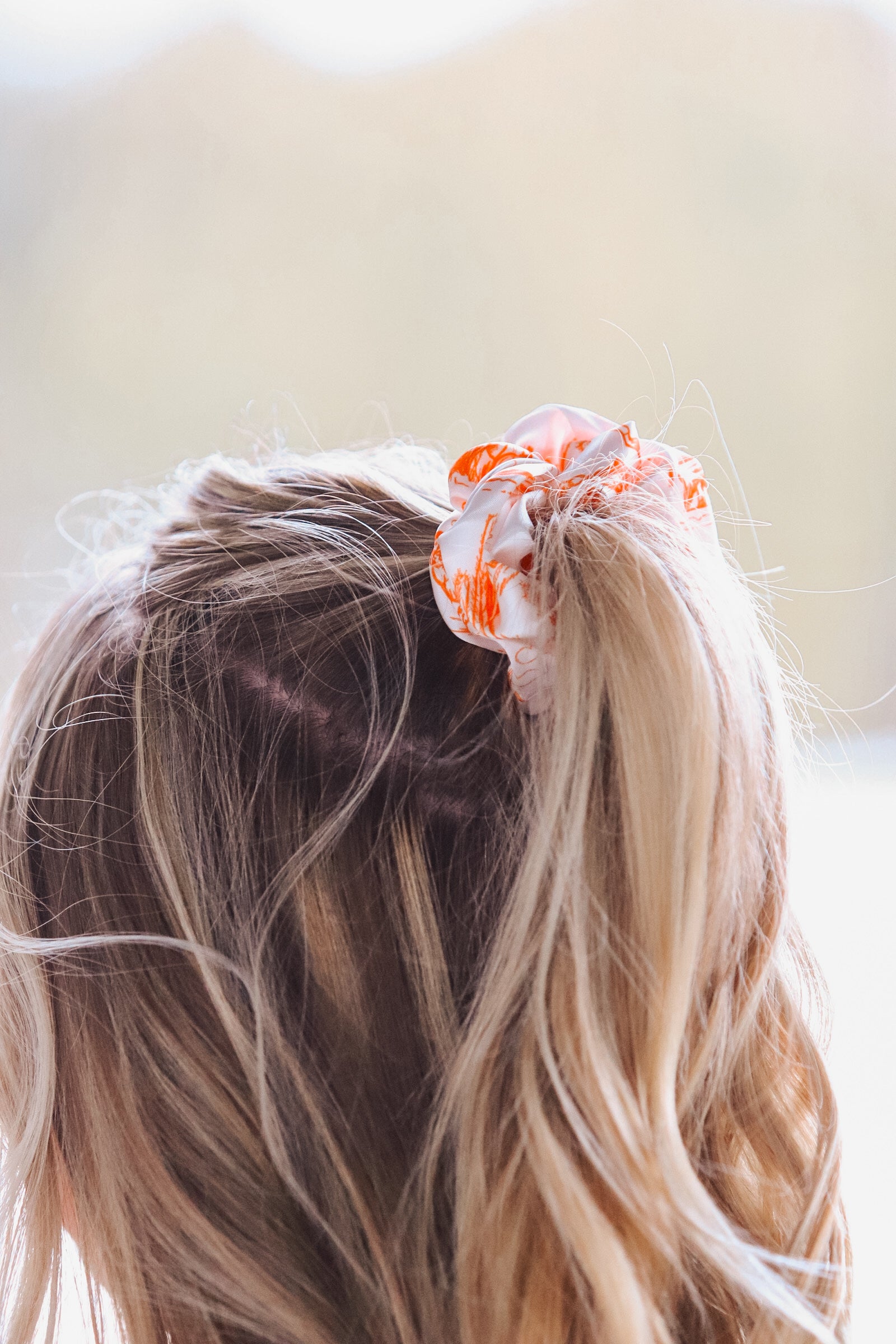 Western inspired orange and white cowboy scene scrunchie in blonde hair