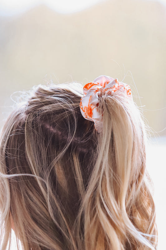Western inspired orange and white cowboy scene scrunchie in blonde hair