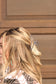Close-up of silver and pearl claw clip holding blonde hair outdoors