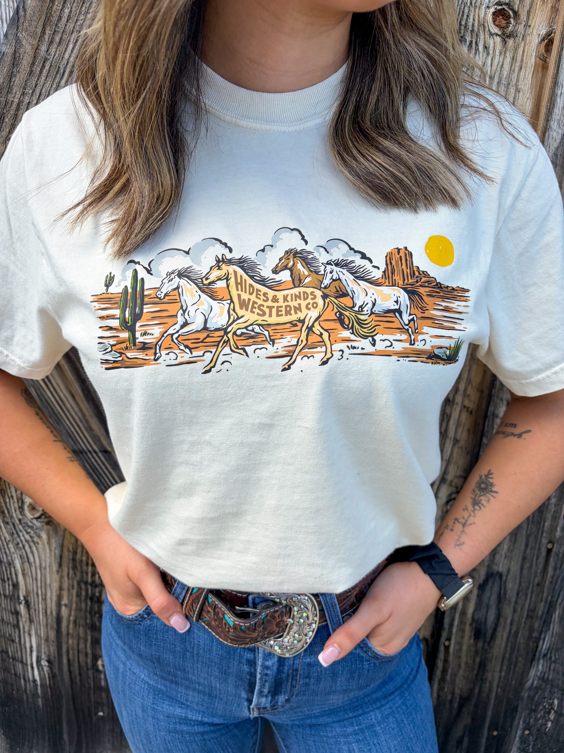 Close up of Wild Run Tee in ivory featuring running horses western graphic design by Hides & Kinds